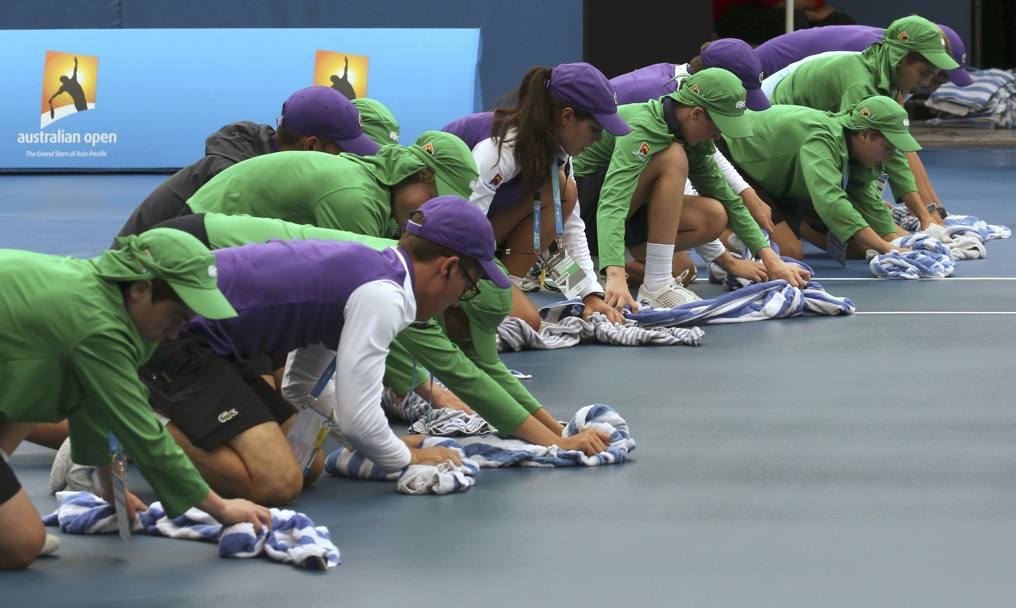 Melbourne, Australian Open: i raccattapalle impegnati nell&#39;asciugatura del campo dopo la pioggia (REUTERS)